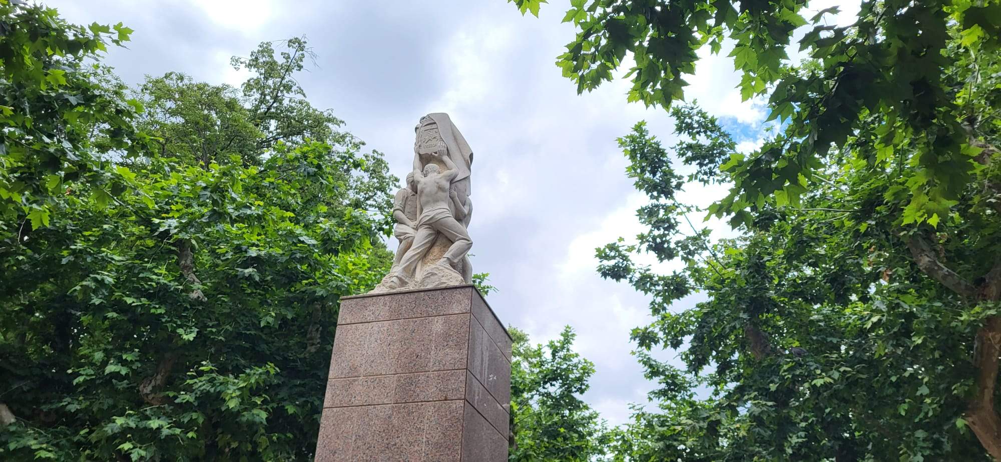 Monumento en el parque coronado por el escudo de Huesa