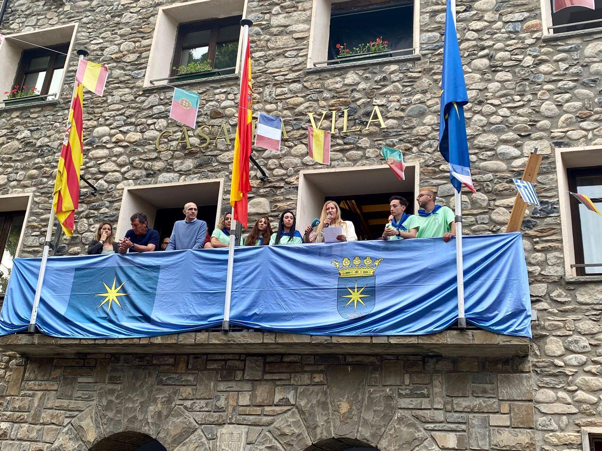 Luz Gabás lee el pregón de fiestas junto a los mayordomos y el alcalde.