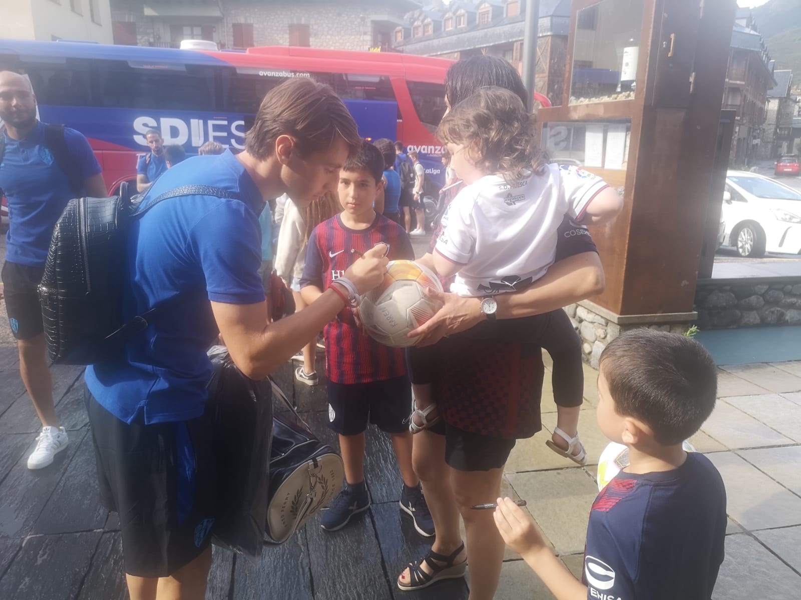 Jóvenes aficionados reciben al Huesca a su llegada a Benasque. Foto: Héctor Rodríguez