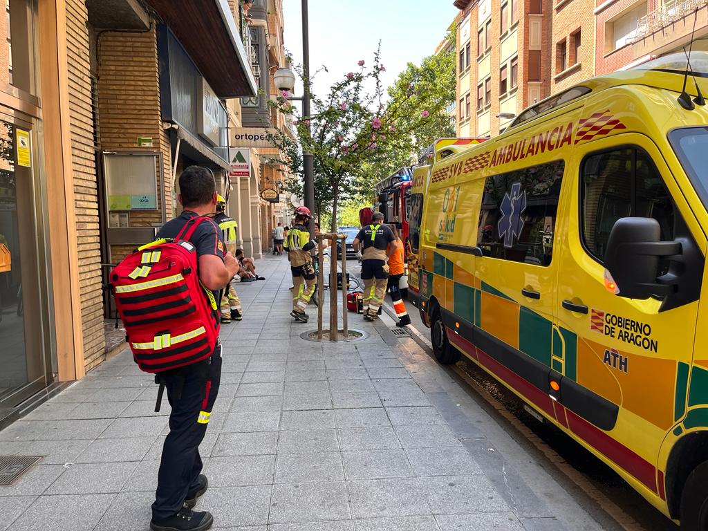 Efectivos de los bomberos y sanitarios junto a la vivienda donde se encontraba la mujer.