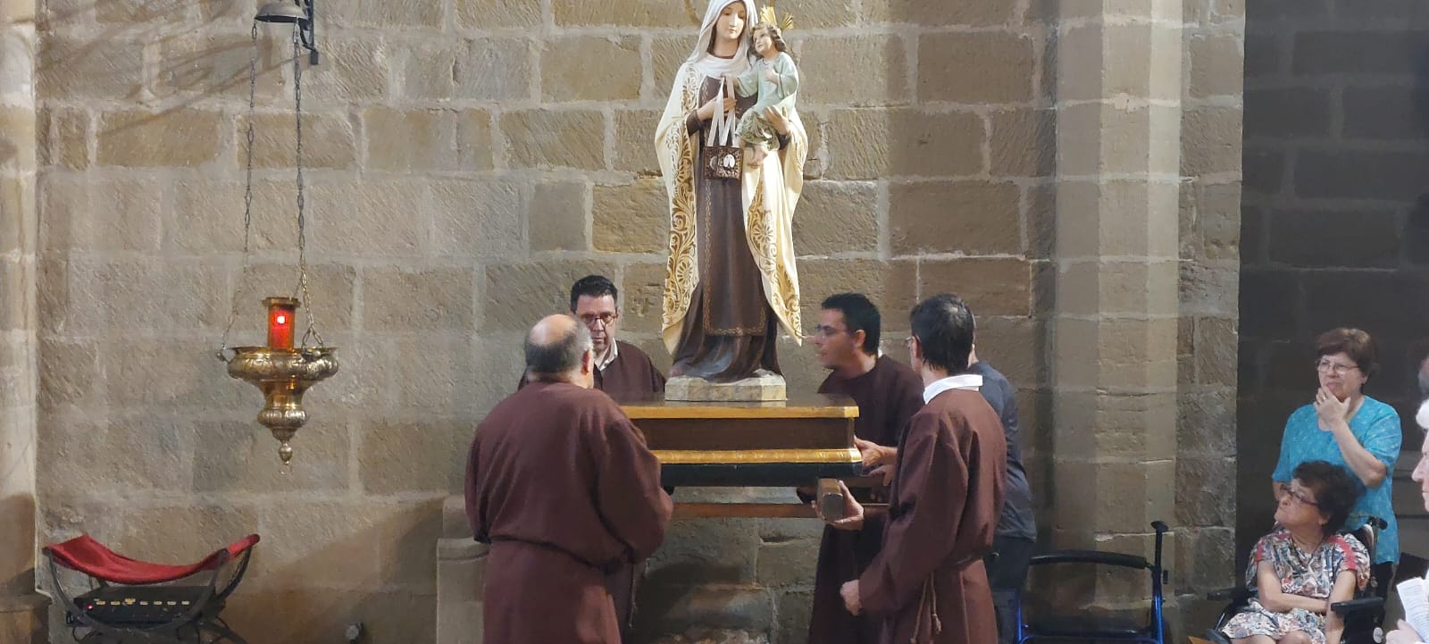 Los monjes se preparan para levantar la figura de la Virgen del Carmen