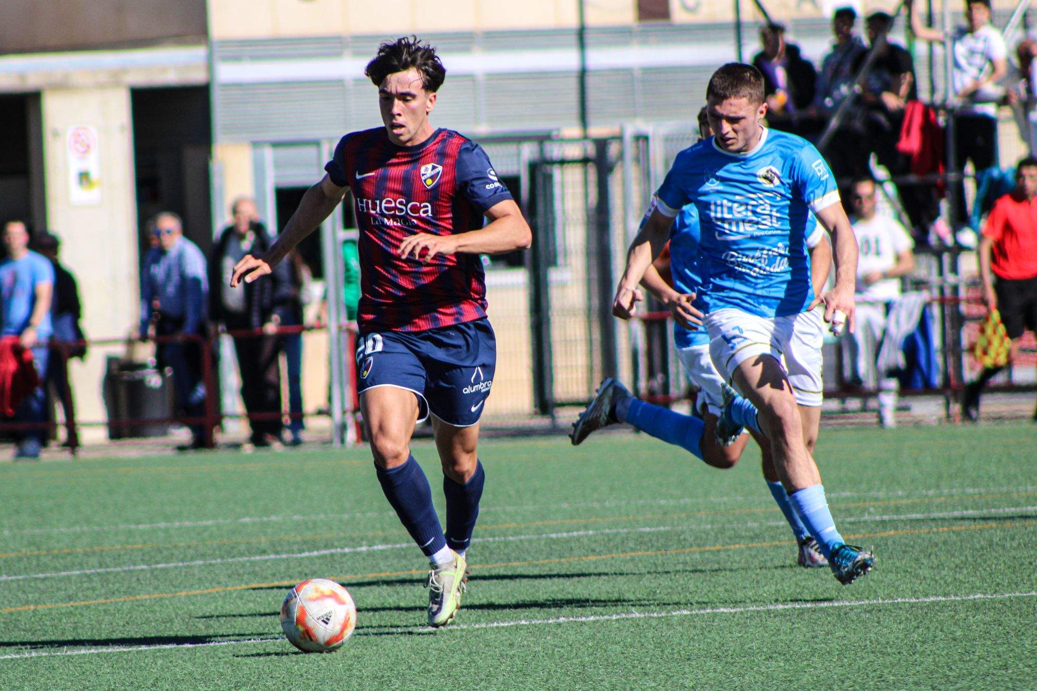 El jugador del Huesca B Jaime Escario conduce un balón ante el Binéfar.