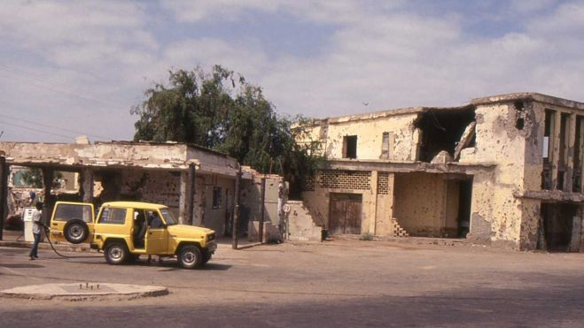 Gasolinera junto a edificios destruidos Gasolinera junto a edificios destruidos