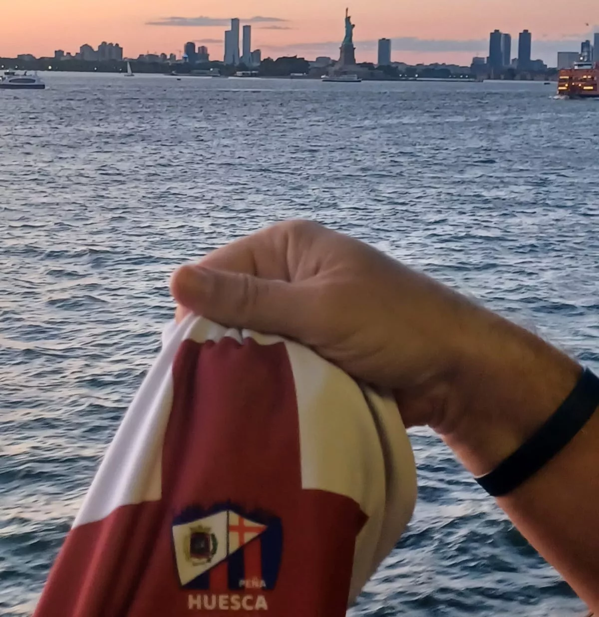 La camiseta de la Peña de la SD Huesca en Barcelona, sobrepuesta con la vista en la Estatua de la Libertad